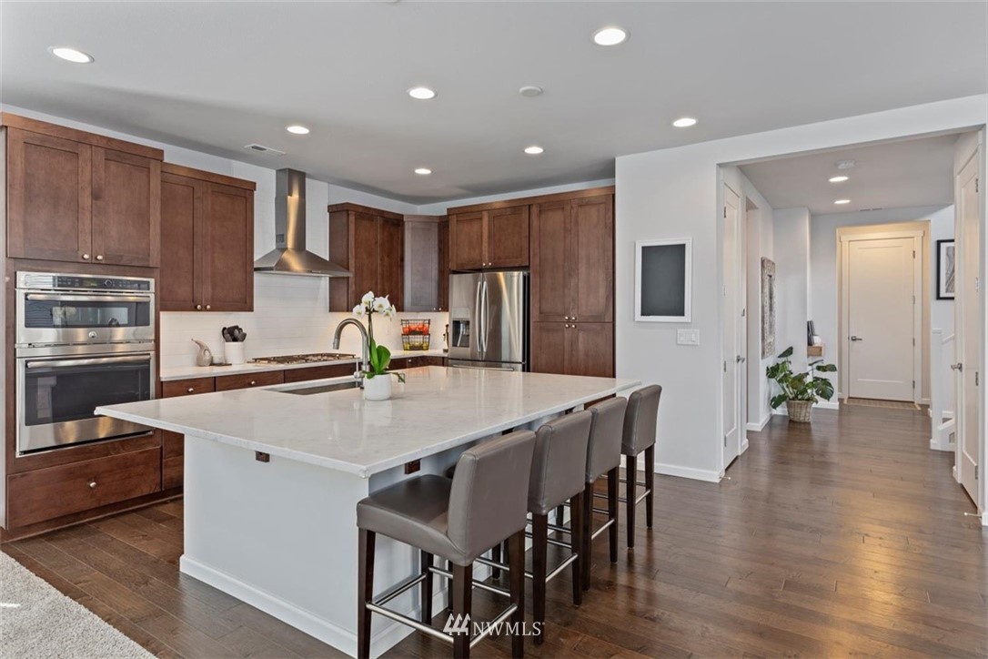320 181st Street Southeast Bothell, WA 98012 - Photo 8 of 40 a kitchen with stainless steel appliances a dining table chairs and wooden floor