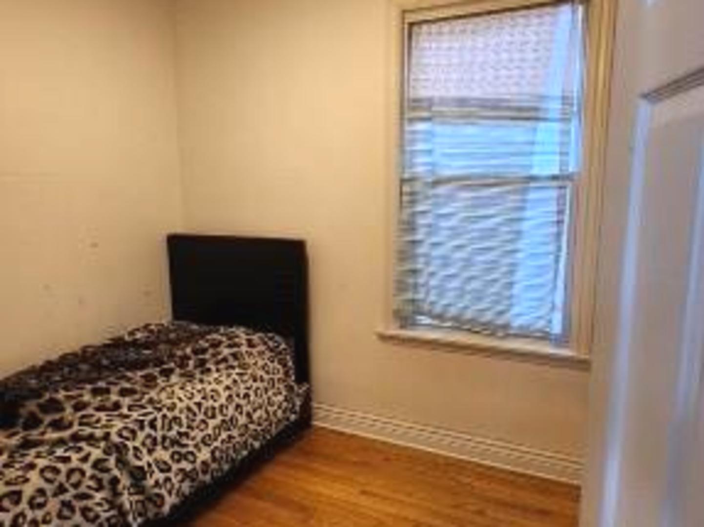 Undisclosed Address Chicago, IL 60641 - Photo 12 of 20 a bedroom with a bed and wooden floor