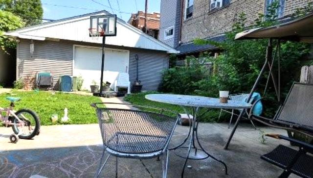 Undisclosed Address Chicago, IL 60641 - Photo 16 of 20 a view of backyard with table and chairs under an umbrella