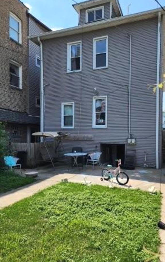 Undisclosed Address Chicago, IL 60641 - Photo 17 of 20 a front view of house with yard and outdoor seating