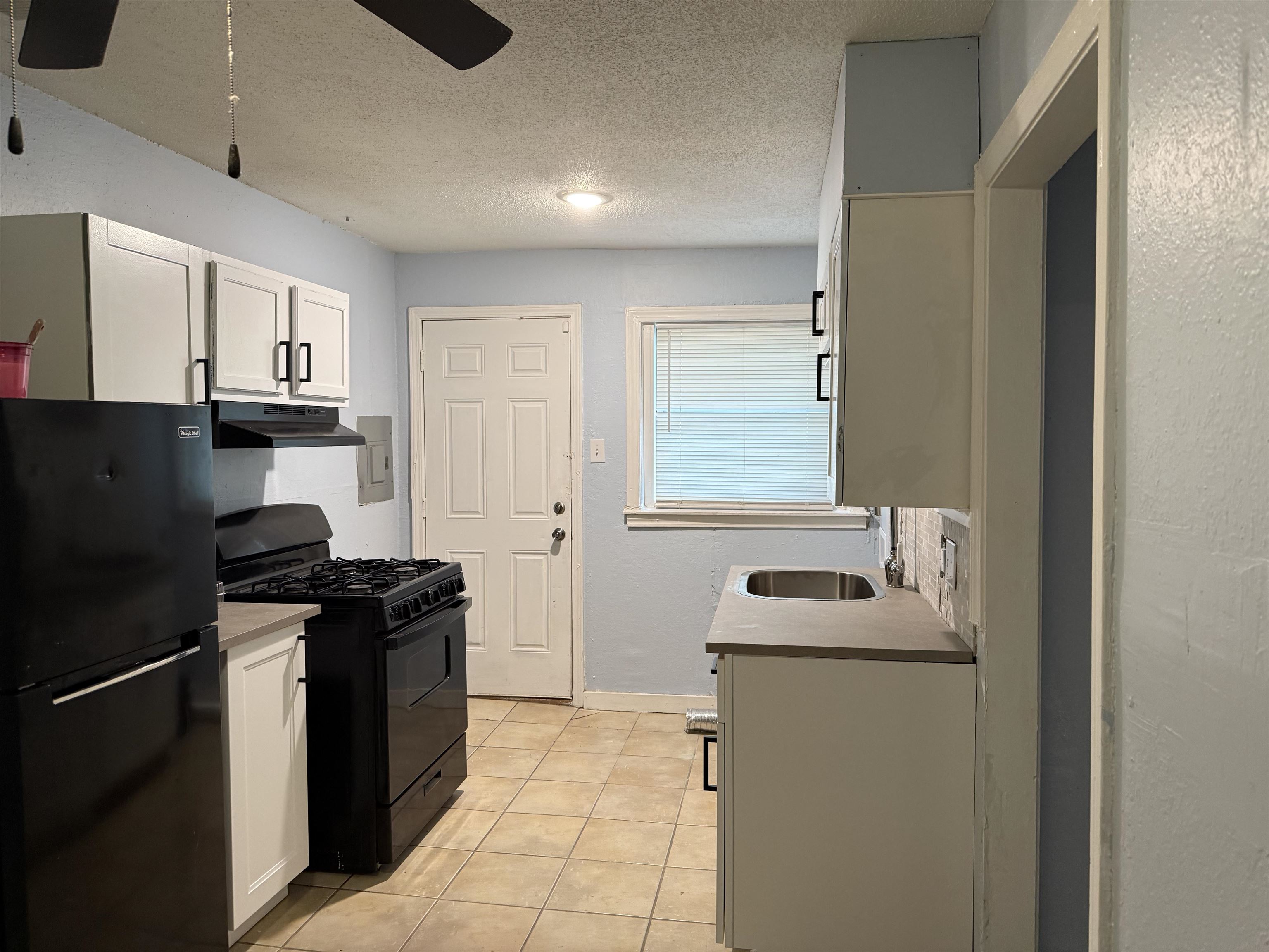 1248 Meda Street Memphis, TN 38114 - Photo 17 of 24 Kitchen featuring black appliances, a textured ceiling, white cabinets, a ceiling fan, and light countertops