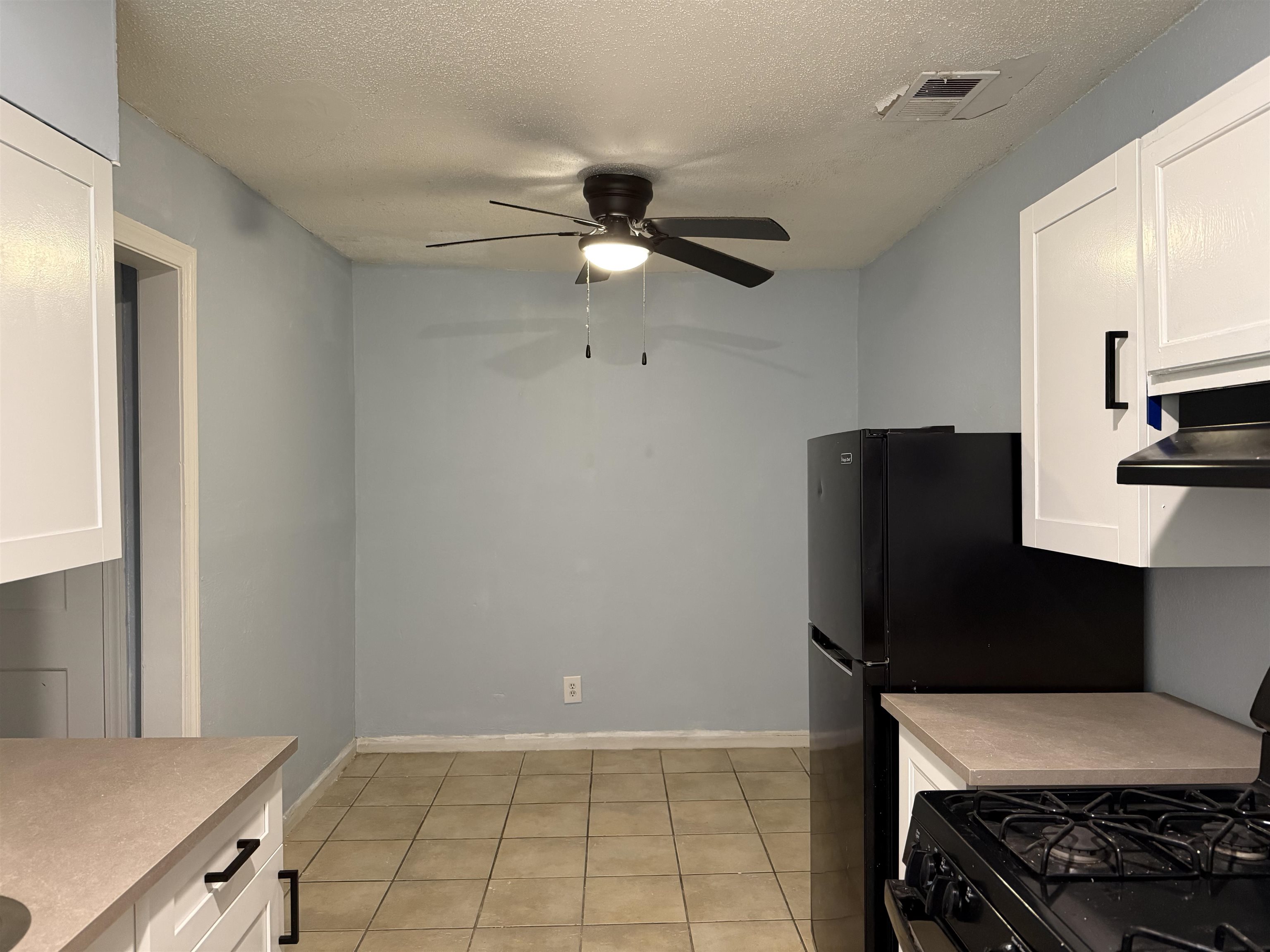 1248 Meda Street Memphis, TN 38114 - Photo 18 of 24 Kitchen featuring white cabinets, black range with gas stovetop, light countertops, a textured ceiling, and a ceiling fan