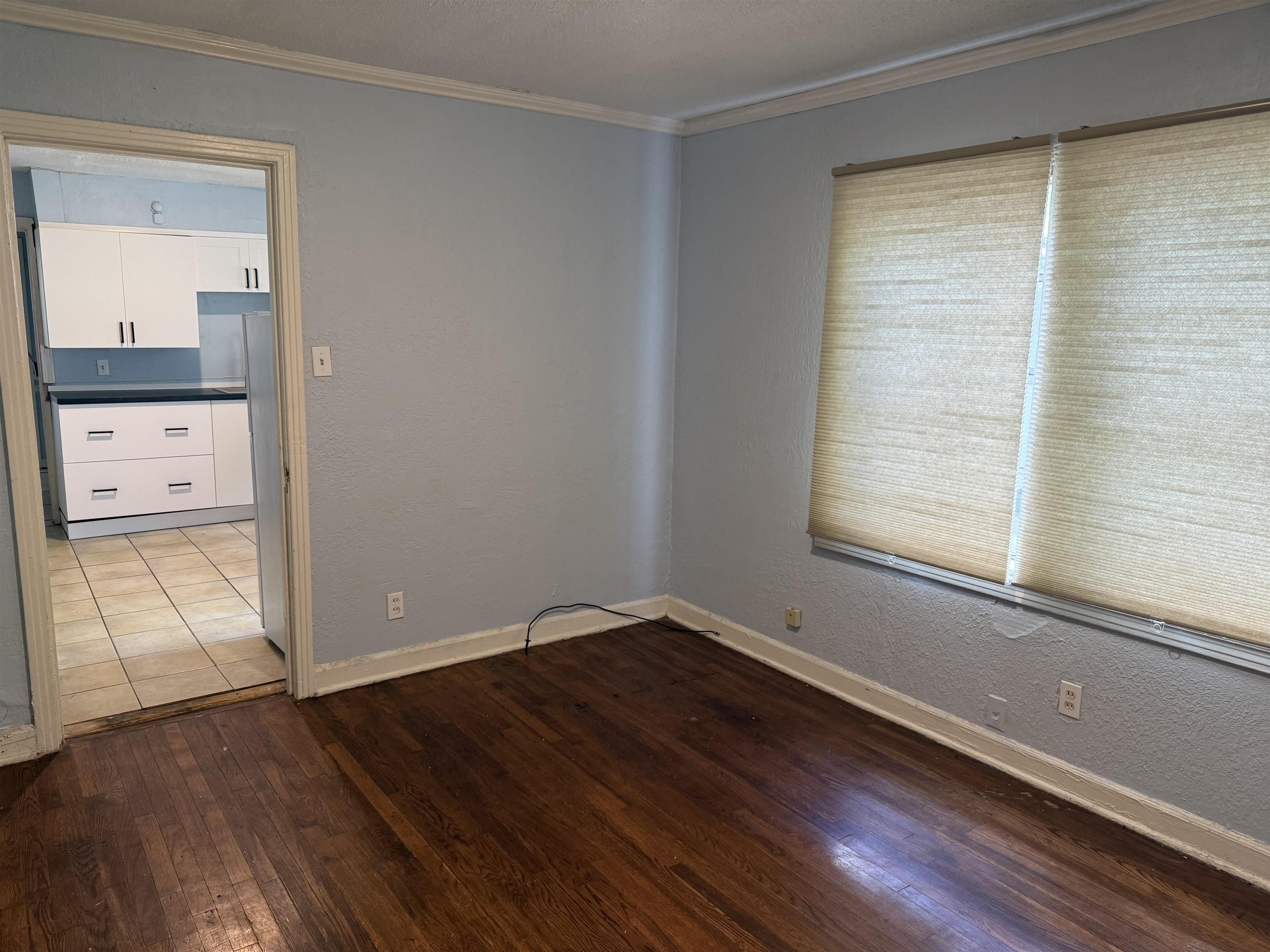 1248 Meda Street Memphis, TN 38114 - Photo 2 of 24 Unfurnished room featuring ornamental molding, dark wood-style floors, and a textured wall