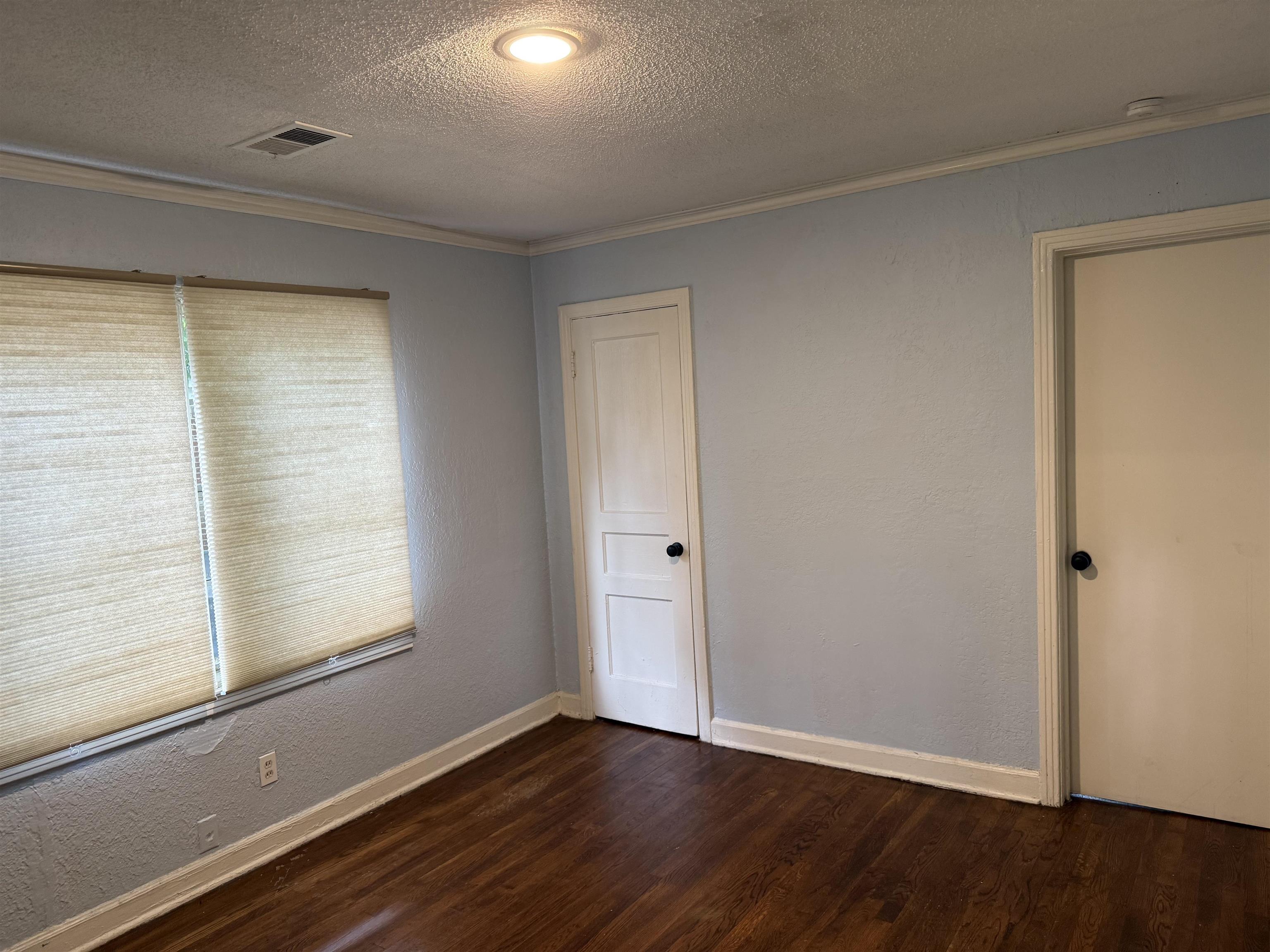 1248 Meda Street Memphis, TN 38114 - Photo 3 of 24 a view of an empty room with wooden floor and a window