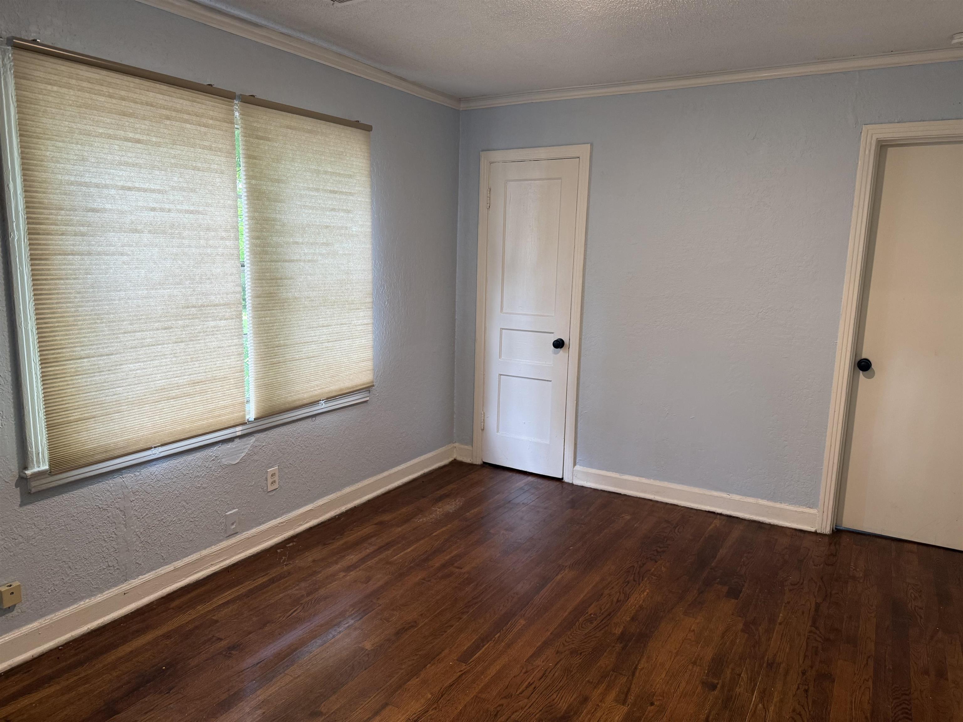 1248 Meda Street Memphis, TN 38114 - Photo 4 of 24 a view of an empty room with wooden floor and a window