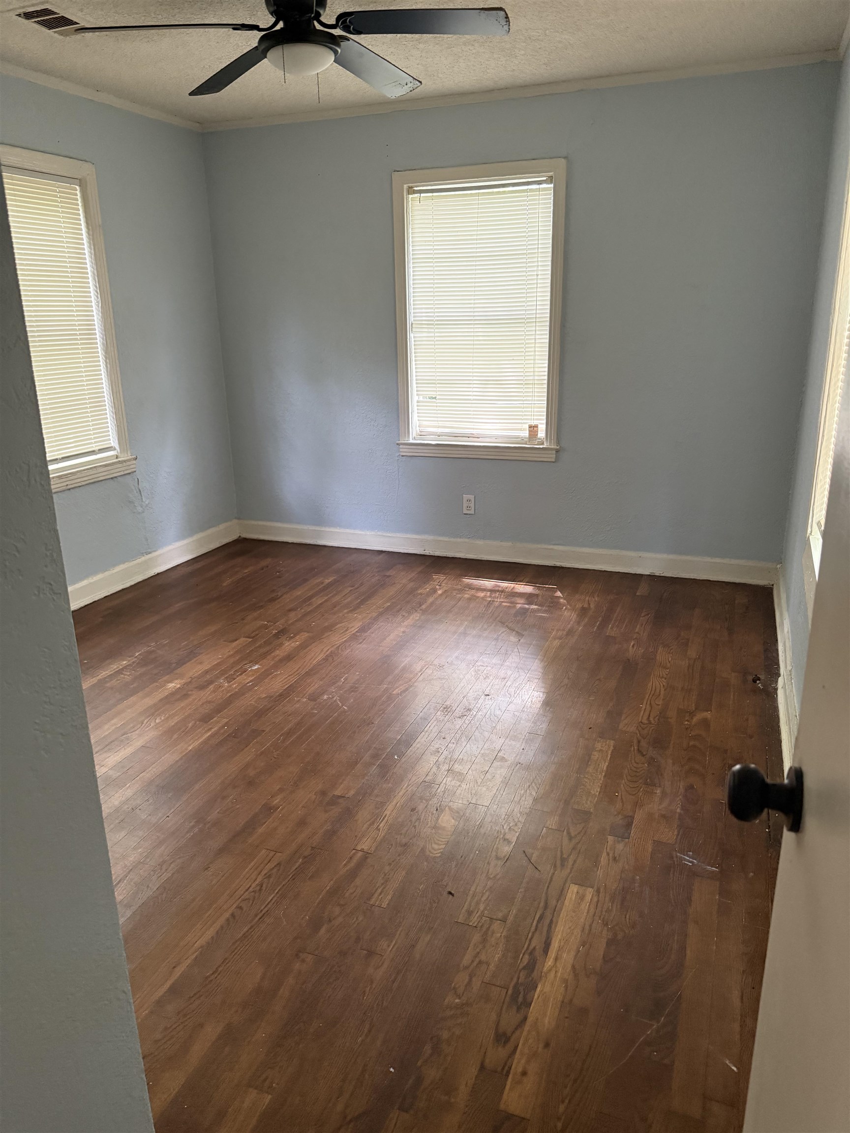 1248 Meda Street Memphis, TN 38114 - Photo 10 of 24 Unfurnished room featuring dark wood finished floors, a textured ceiling, plenty of natural light, crown molding, and ceiling fan