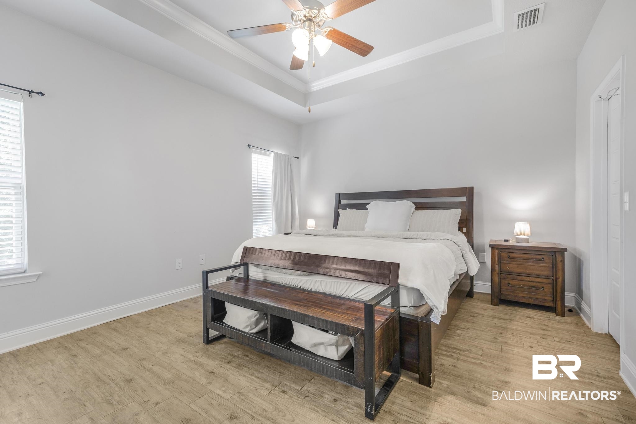 31336 Hoot Owl Road Daphne, AL 36527 - Photo 11 of 36 Bedroom with a raised ceiling, light wood-style floors, ceiling fan, and ornamental molding