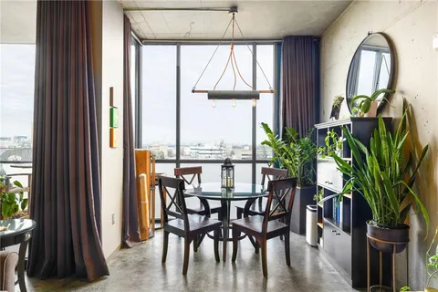 a dining room with furniture potted plants and wooden floor