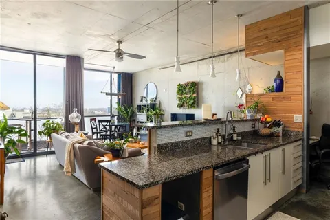 a kitchen with counter top space a sink and living room view