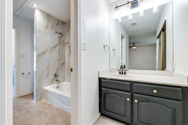 a bathroom with a tub sink and mirror