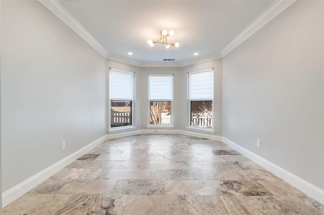 an empty room with windows and chandelier