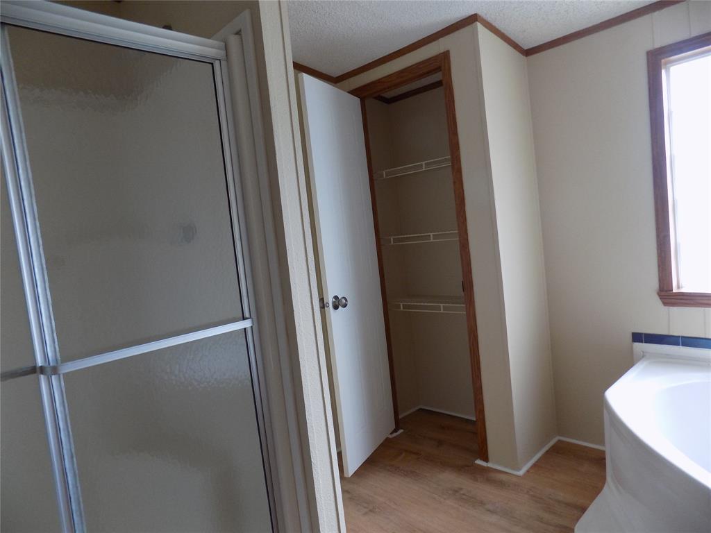 3450 Sarra Lane Springtown, TX 76082 - Photo 11 of 23 Primary bathroom with shower stall, garden tub, linen closet and healthy amount of natural light.