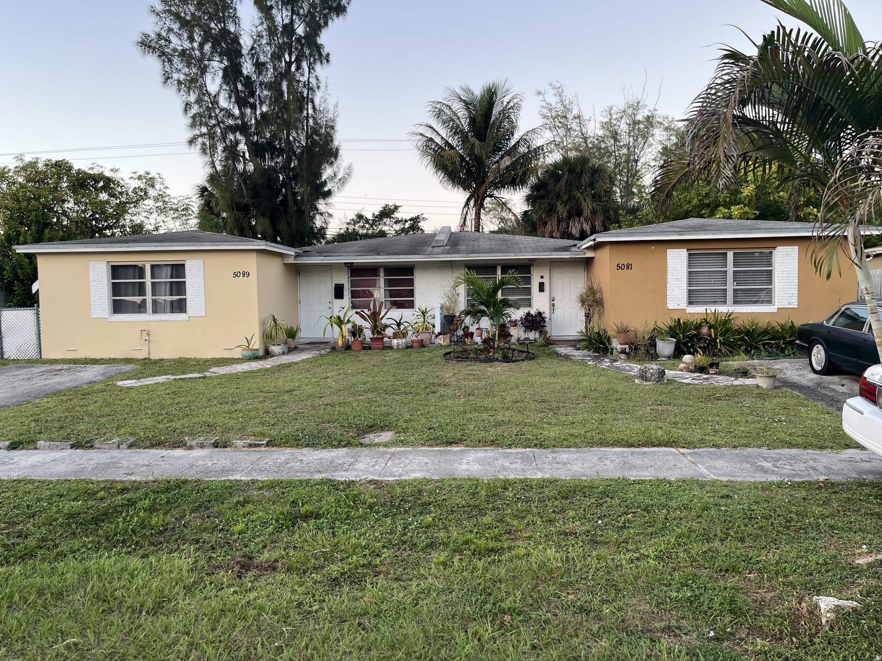 a front view of a house with a garden and trees