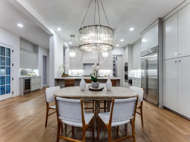 a view of a dining room with furniture a chandelier and wooden floor