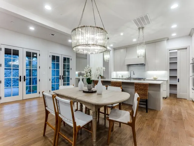 a view of a dining room with furniture a chandelier and wooden floor