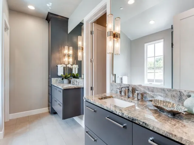 a bathroom with a granite countertop sink and a mirror