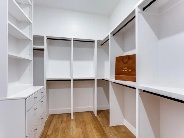 a view of walk in closet with empty racks