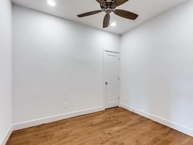 an empty room with a window and a fan