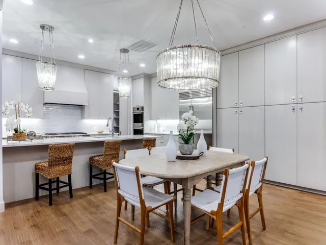 a kitchen with a dining table chairs and wooden floor