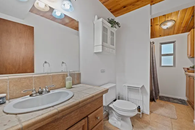 a bathroom with a granite countertop toilet sink and mirror