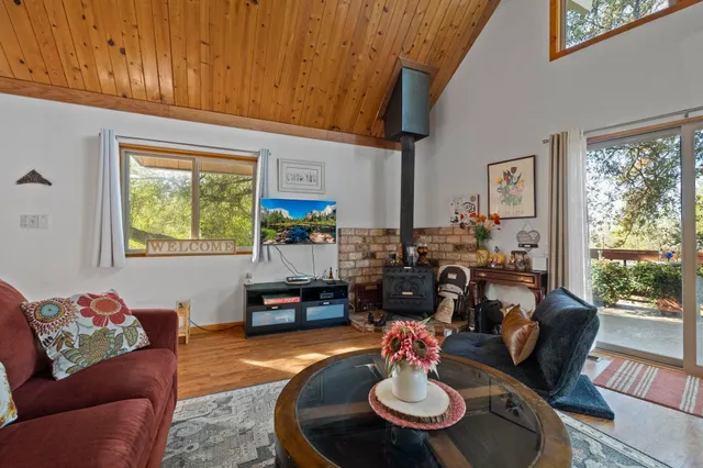 a living room with furniture and a dining table with wooden floor