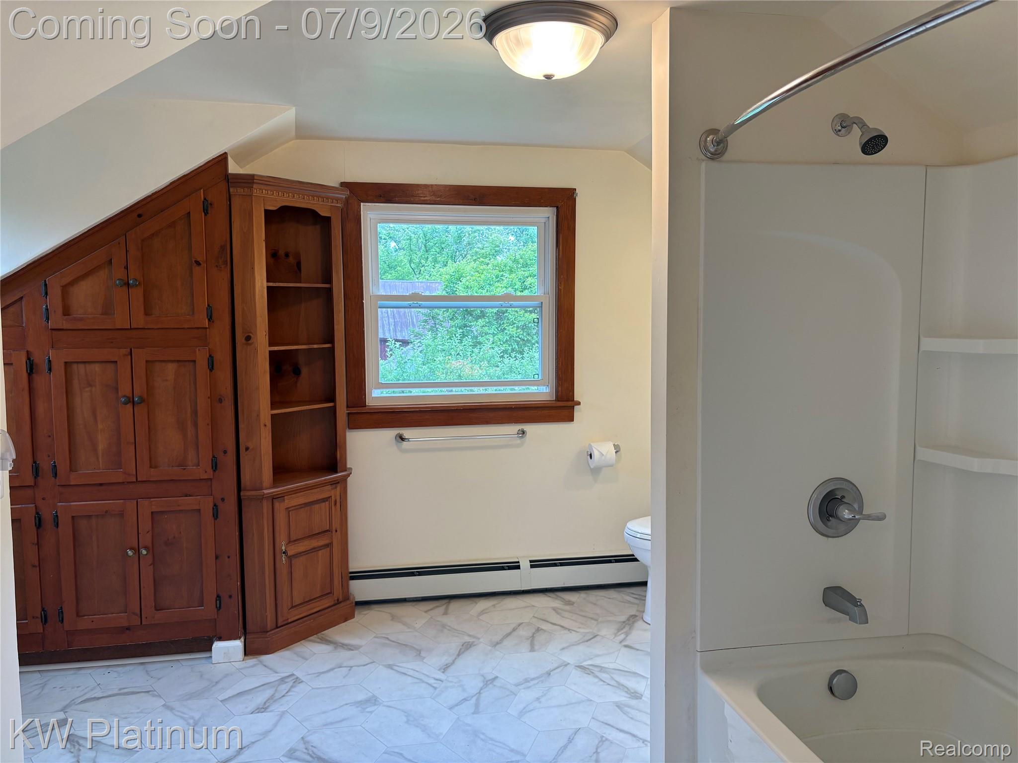 7280 North Road Fort Gratiot, MI 48059 - Photo 4 of 40 Bathroom featuring a built-in wood cabinet system with shelving, a window with wood trim, and light-toned patterned flooring