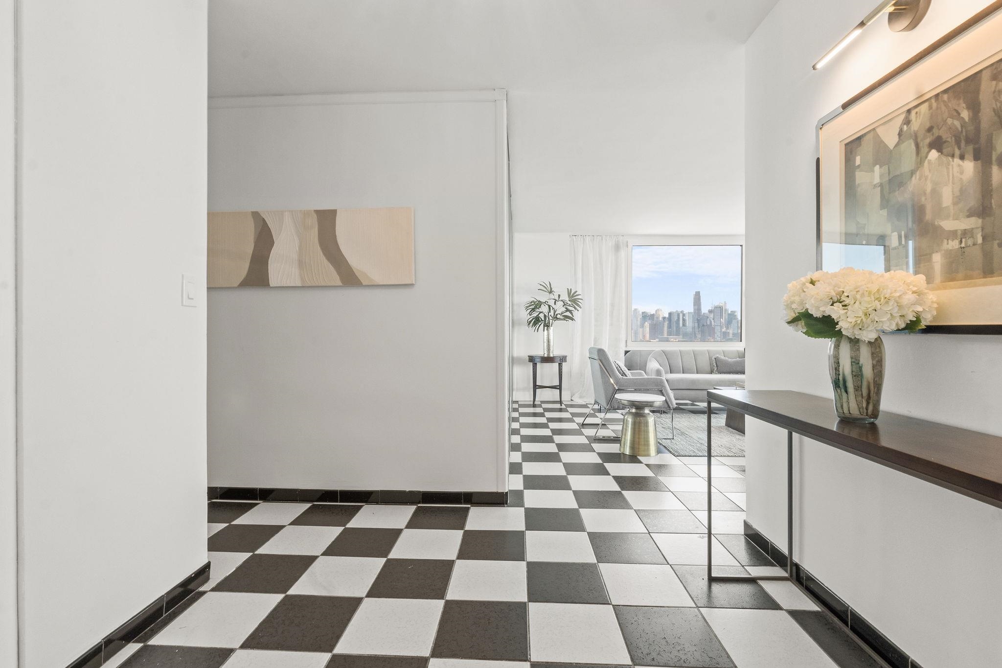 380 Mountain Road, Unit 1112 Union City, NJ 07087 - Photo 14 of 42 a living room with a black white checkered floor with a gaming machine and a view of living room