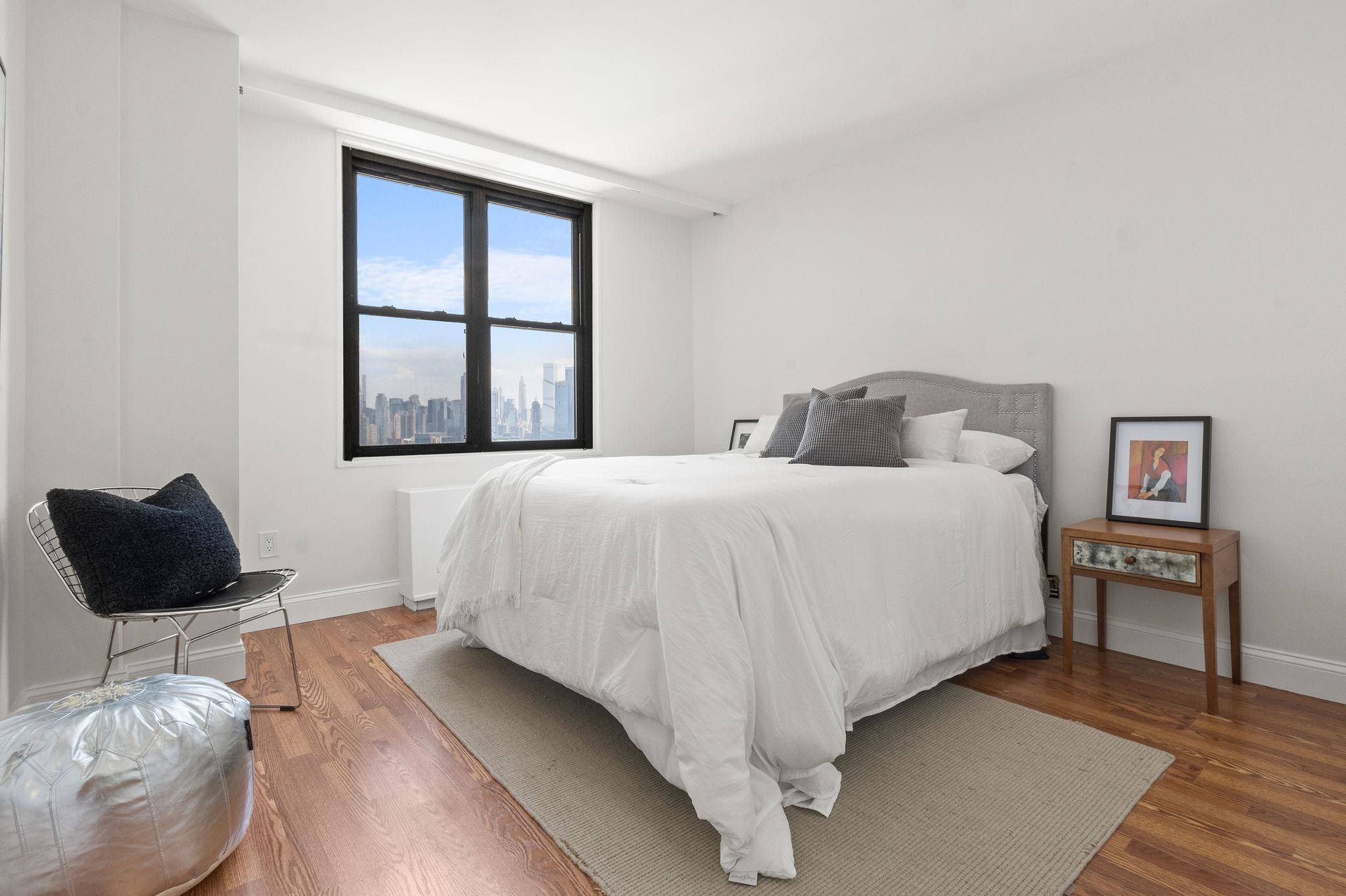 380 Mountain Road, Unit 1112 Union City, NJ 07087 - Photo 23 of 42 a bedroom with a bed and wooden floor