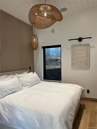 a bedroom with a large bed and a chandelier