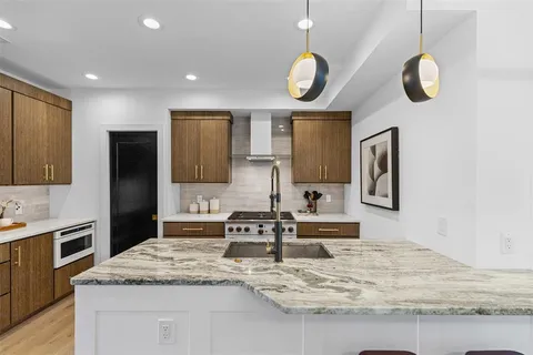 a kitchen with stainless steel appliances granite countertop a sink and a stove