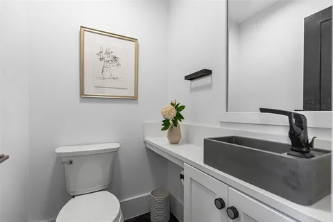 a bathroom with a toilet a sink and mirror