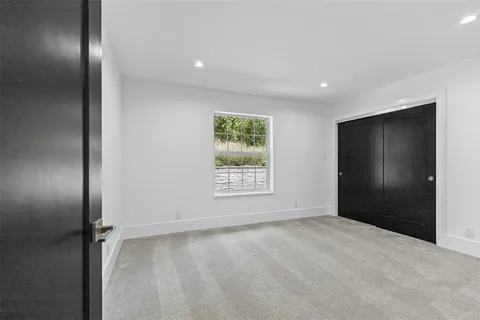 a view of an empty room with window and closet area