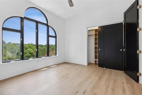 a view of an empty room with a window and bathroom