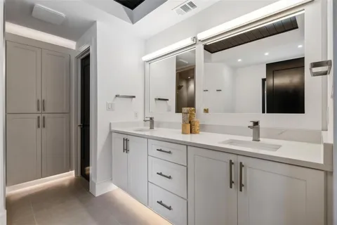 a bathroom with a double vanity sink and mirror