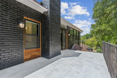 a view of balcony with floor to ceiling window and wooden fence