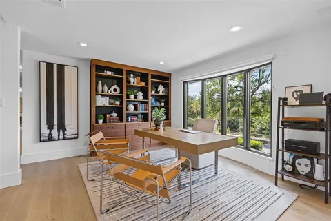 a living room with furniture a bookshelf and wooden floor