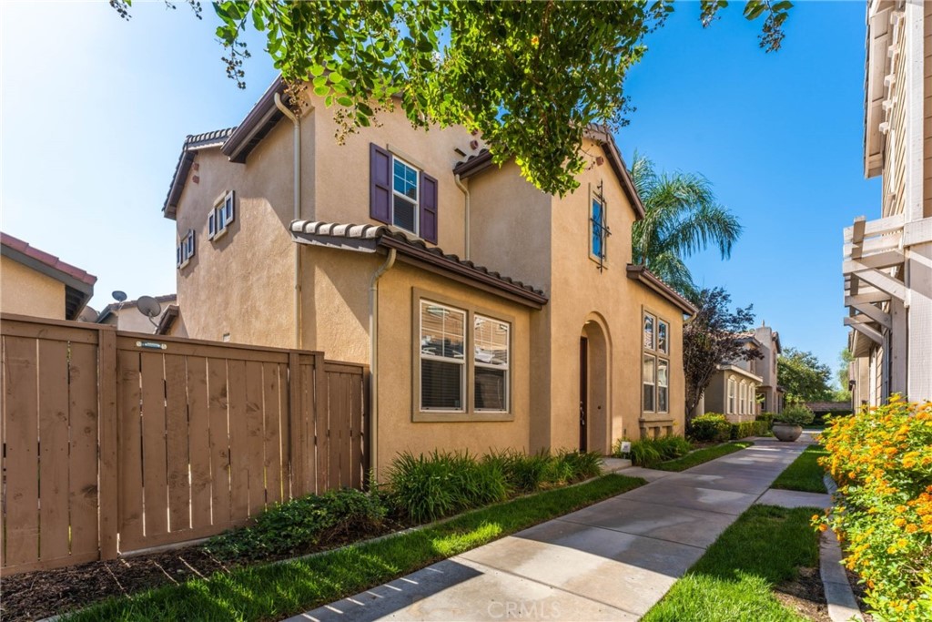 1869 Flint Court Riverside, CA 92501 - Photo 1 of 1 a view of a blue house with a large windows and flower plants