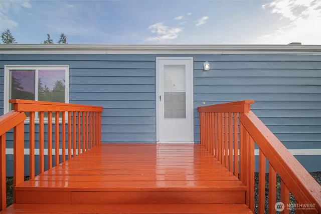 a view of a balcony with wooden floor and fence and a potted plant