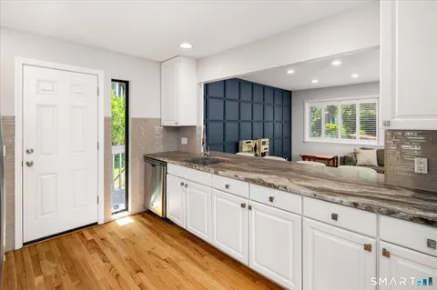 a kitchen with granite countertop cabinets stainless steel appliances a sink and a window