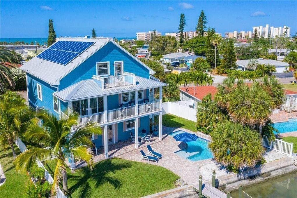 a view of a house with a yard and potted plants