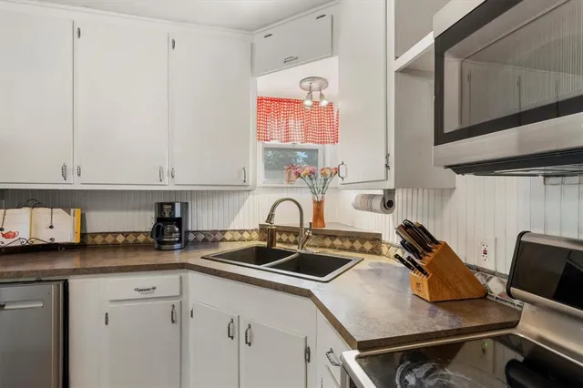 a kitchen with a sink cabinets and appliances