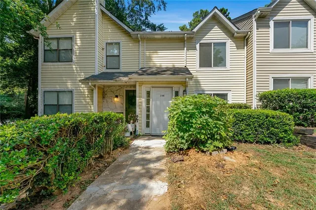 a front view of a house with a yard and potted plants
