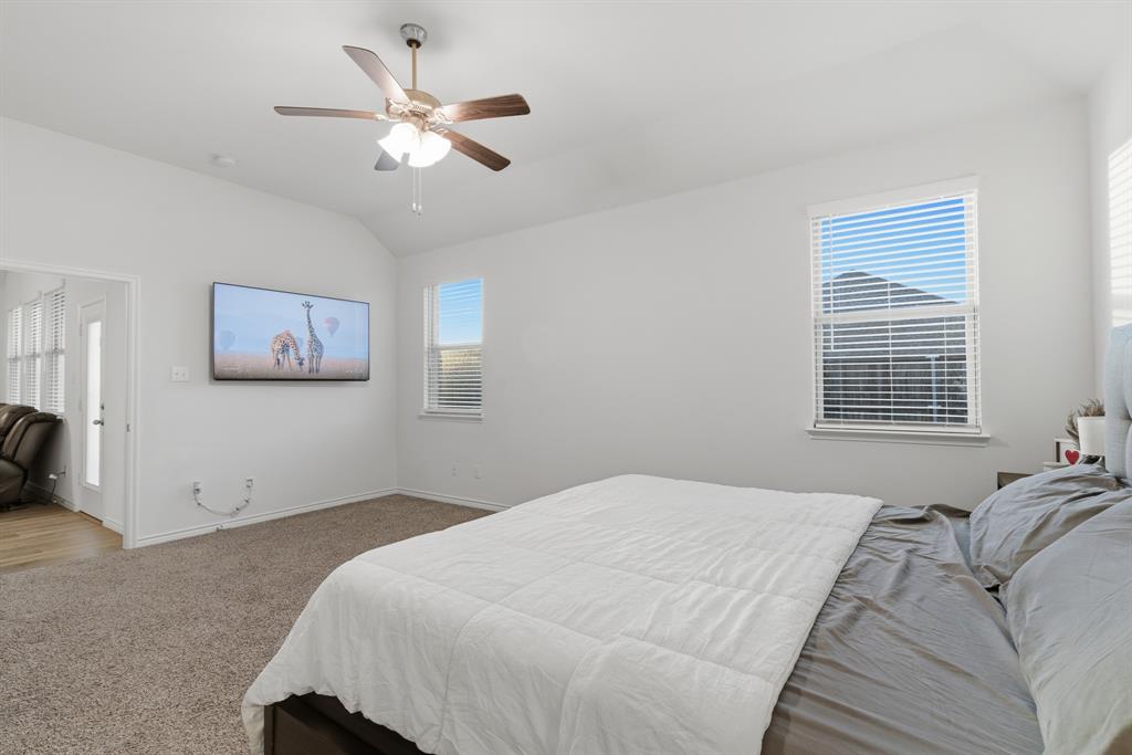 727 Fort Lane Fate, TX 75189 - Photo 14 of 19 a bedroom with a large bed and a ceiling fan
