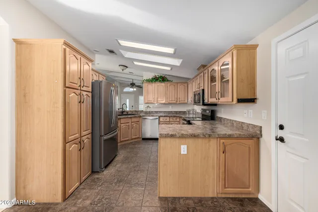 a kitchen with stainless steel appliances granite countertop a refrigerator a stove and a sink