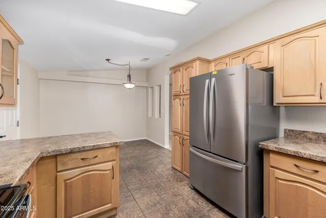 a kitchen with stainless steel appliances granite countertop a refrigerator and a stove top oven