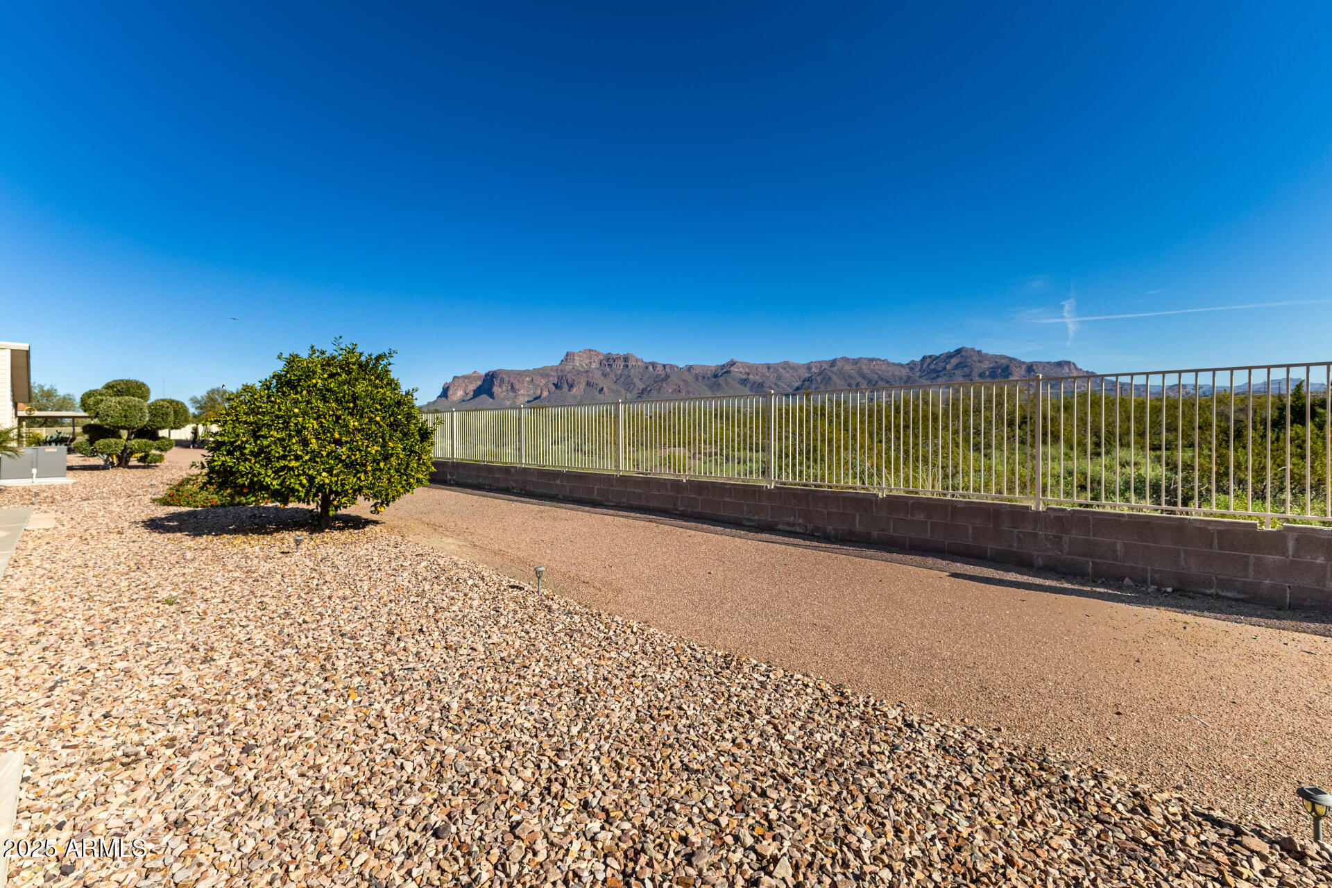 3301 South Goldfield Road, Unit 4018 Apache Junction, AZ 85119 - Photo 38 of 45 a view of a road with a garden and trees