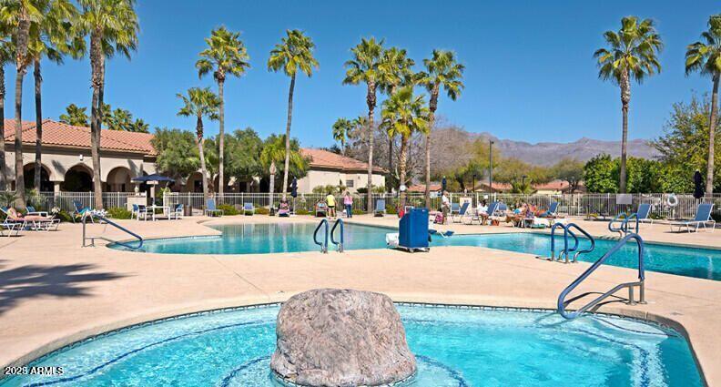 3301 South Goldfield Road, Unit 4018 Apache Junction, AZ 85119 - Photo 43 of 45 a view of a swimming pool with a table and chairs