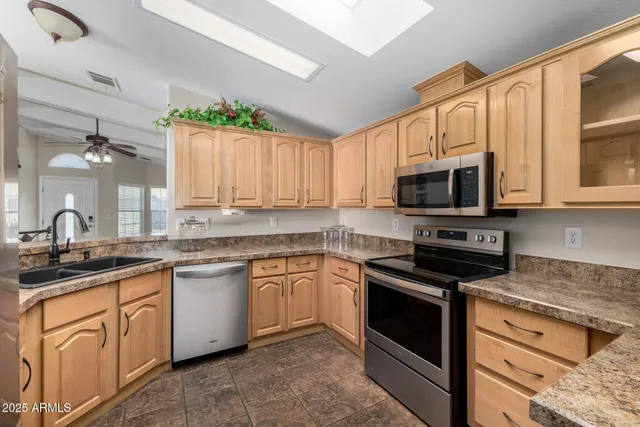 a kitchen with granite countertop white cabinets stainless steel appliances and a sink