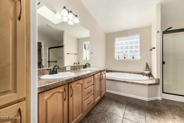 a bathroom with a granite countertop sink a toilet a mirror and bathtub