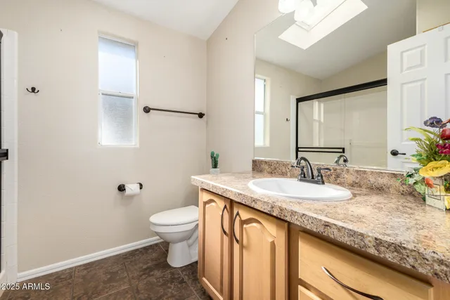 a bathroom with a granite countertop sink a toilet and a mirror